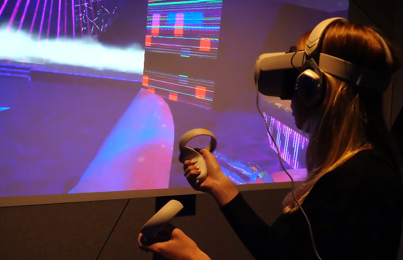 A participant wearing a VR headset in front of vivid digital imagery.