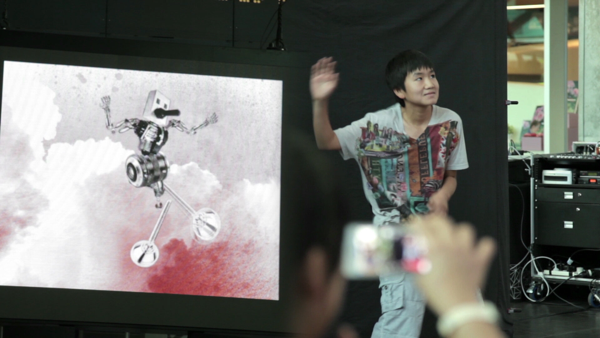 A participant animates a digital puppet on a public screen.