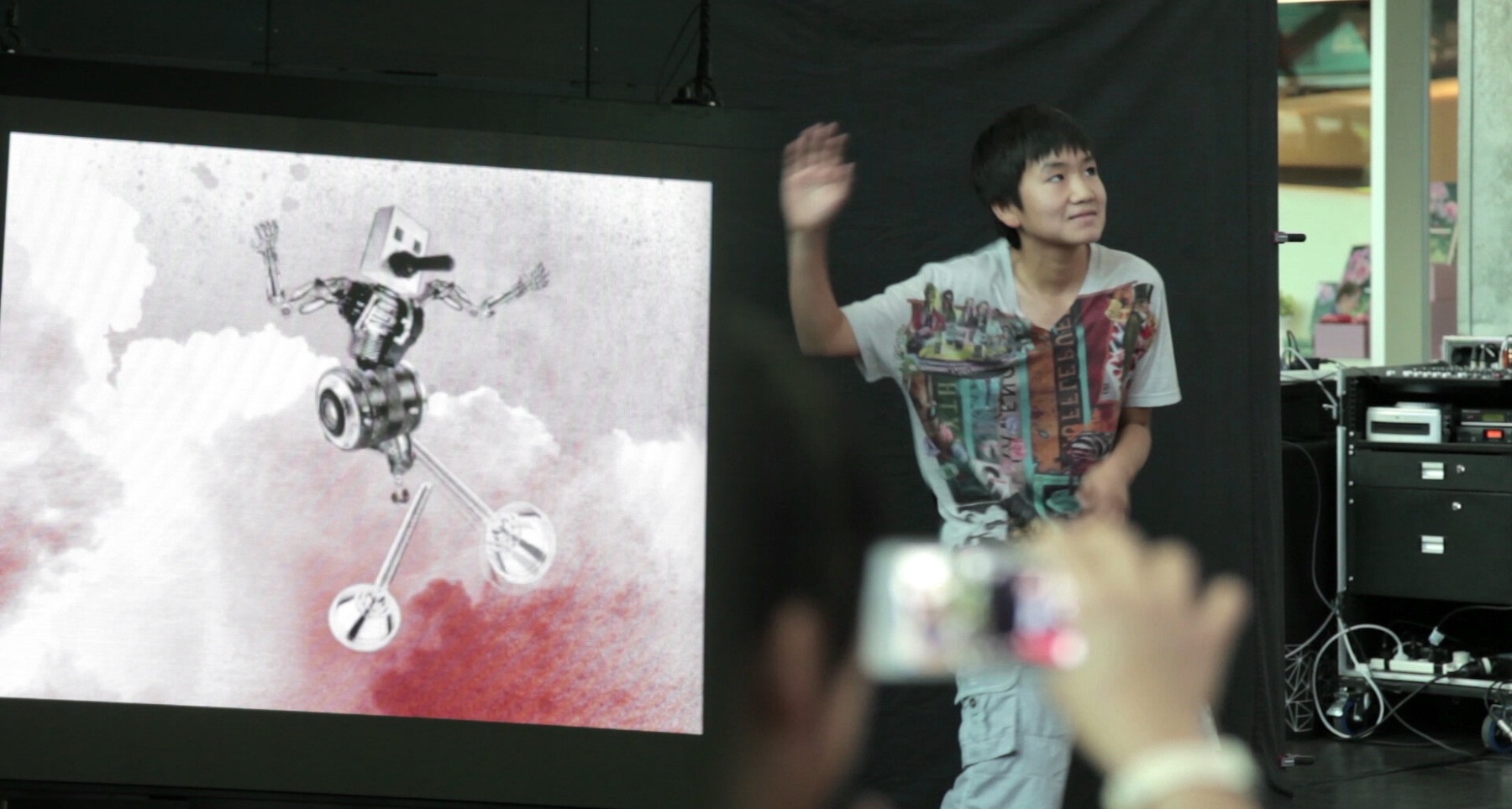 A child animating their digital puppet on a public screen.
