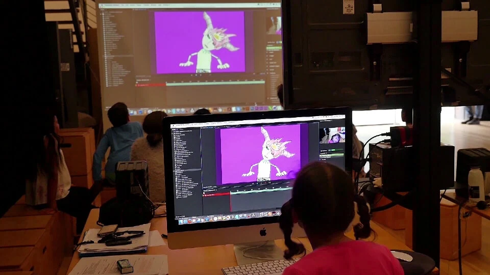 Participants use an animation interface with a character projected onto a screen.